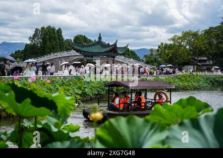 Kunming, China's Yunnan Province. 7th July, 2024. Visitors on boats enjoy lotus flowers at Daguan Park in Kunming, southwest China's Yunnan Province, July 7, 2024. Credit: Hu Chao/Xinhua/Alamy Live News Stock Photo