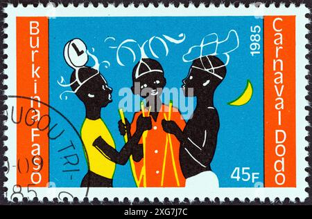 BURKINA FASO - CIRCA 1985: A stamp printed in Burkina Faso from the 'Dodo Carnival' issue shows three dancers Stock Photo