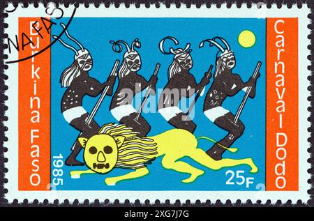 BURKINA FASO - CIRCA 1985: A stamp printed in Burkina Faso from the 'Dodo Carnival' issue shows Lion and four dancers Stock Photo