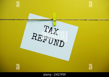 Tax Refund text on paper card hanging on the wall with Clothespins Stock Photo