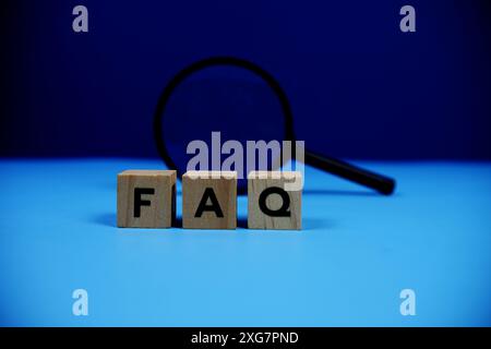 FAQ with wooden blocks alphabet letters and Magnifying glass on blue background Stock Photo