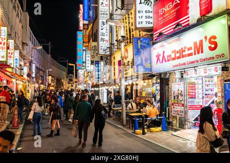 Evening view along the brightly lit shops and restaurants running under the railway tracks at the very popular Ueno Ameyoko shopping district in Tokyo Stock Photo