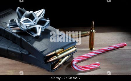 Silver and white bow, spare ammo and a candy cane on a table for the ideal gun owner's Christmas gift. Stock Photo