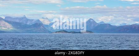 Panoramic view of the majestic Lofoten Islands, featuring rugged mountains and clear blue skies reflected in the calm sea. A stunning and serene natur Stock Photo