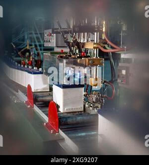 testing  lead-acid batteries , checking voltage with probes amid wiring in lab environment under bright lights Stock Photo