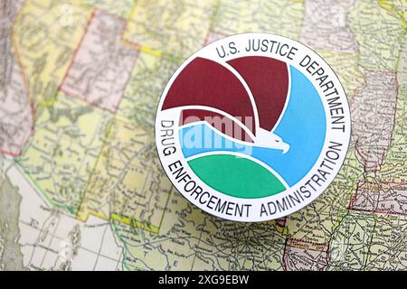 KYIV, UKRAINE - JUNE 26, 2024 U.S. Justice Department Drug Enforcement Administration coat of arms on paper map of United States of America Stock Photo