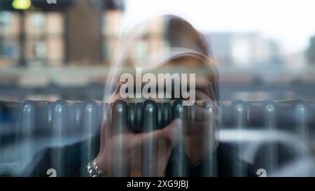 Photographer is reflected in a glass pane while looking through the camera Stock Photo