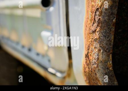 Fragment of a car body with rust. fragment of a rusty wing of a car. The body element is corroded. Concept: corrosion resistance, body repair, rust. Stock Photo