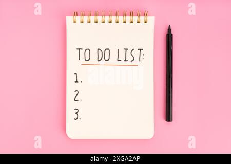To do list in spiral notepad isolated on pink background. Top view Stock Photo