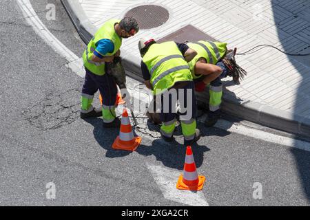 Group of construction Workers repairing an asphalt road on city. Paving maintenance Stock Photo