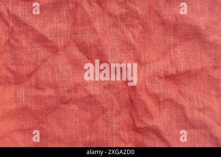 Red Burlap Fabric with Wrinkles background texture. Full Frame Stock Photo