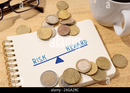 Risk reward concept. Drawing on notepad and coins on desk Stock Photo