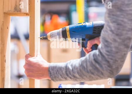 Do it yourself home handyman is using a cordless screwdriver for screwing Stock Photo