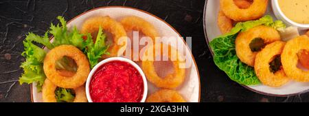 Calamari rings panorama. Deep fried squid rings with green salad and various dips, top flat lay shot on a dark background Stock Photo