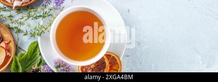Herbal tea panorama with copy space. Herbs, flowers and fruit with a cup of tea, an overhead flat lay shot Stock Photo