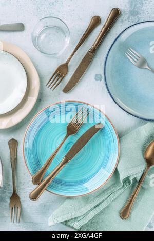 Blue plate and other tableware, shot from above on a table. Elegant dinner service Stock Photo