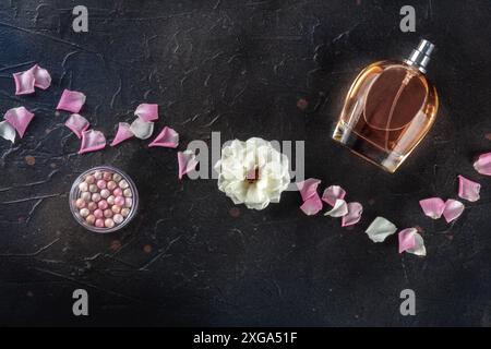 Beauty and cosmetics concept. A bottle of perfume and makeup, overhead flat lay shot on a black background with copy space Stock Photo