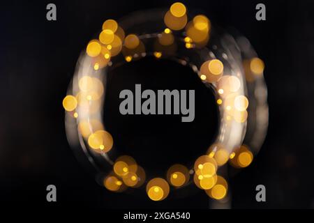 Fairy lights, led garland, blurred overhead flat lay shot with bokeh on a black background. Abstract Christmas frame with copy space Stock Photo