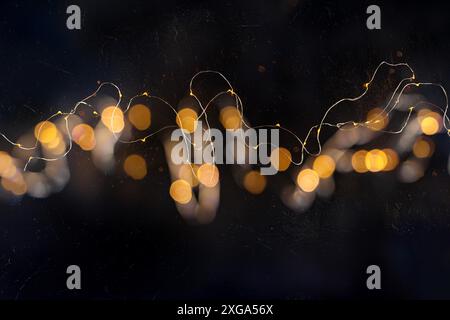 Fairy lights, led garland, blurred overhead flat lay shot with bokeh on a black background. Abstract Christmas banner with copy space Stock Photo