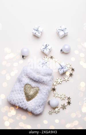 White fluffy sack with small gift boxes on beige background, flat lay vertical Stock Photo