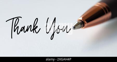 Thank you text on white background with close up of pen Stock Photo