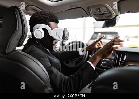 Businessman exploring car interior using virtual reality headset in dealership Stock Photo