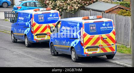 Two of a kind Affinity Water engineers vans parked up in village residential street crews attending to householders supply problems  Essex England UK Stock Photo