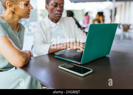 Two Professional Women Working Together at a Cafe Stock Photo