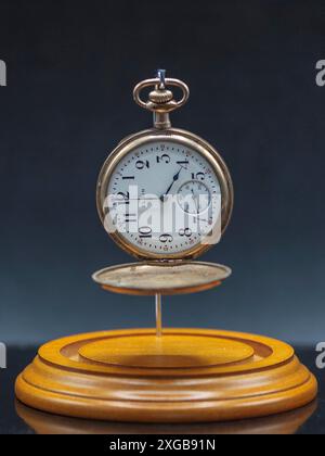 old open faced gold pocket watch a family heirloom from an unclear lineage ago in its display case without the dome Stock Photo