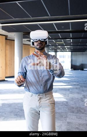 Using VR headset, businessman exploring virtual reality in modern office space Stock Photo