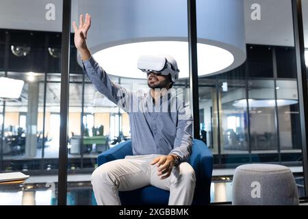Using VR headset, man interacting with virtual environment in modern office Stock Photo