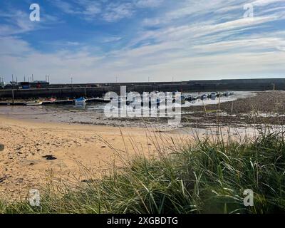 View of the beach and marina at Balintore Harbour near Tain in Scotland on a summer day with blue sky and a bit of cloud Stock Photo