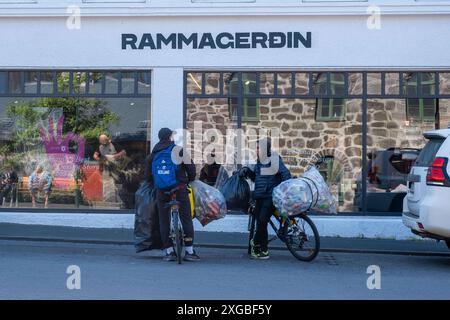 Pfandsammer mit Fahrrädern auf der Straße Skólavörðustígur in der Innenstadt von Reykjavik. Die jugen Männer sammeln Pfandflaschen, um damit ihren Lebensunterhalt zu besteeiten. / Deposit collectors with bicycles on the street Skólavörðustígur in downtown Reykjavik. The young men collect returnable bottles to make a living. Pfandsammer *** Deposit collectors with bicycles on the street Skólavörðustígur in downtown Reykjavik The young men collect returnable bottles to make a living Deposit collectors with bicycles on the street Skólavörðustígur in downtown Reykjavik sp202407071432.jpg Stock Photo