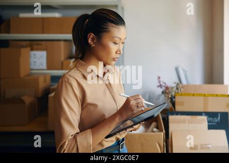 Woman Using Tablet PC In Warehouse Stock Photo