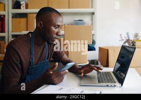 Man Using Laptop In Storage Room Stock Photo