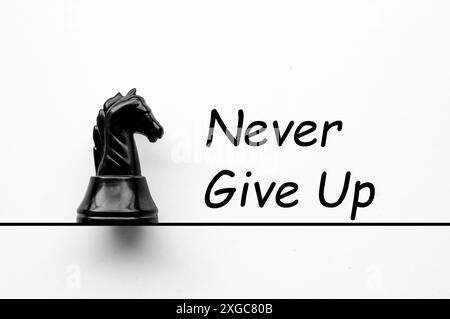 Never Give Up Text With Black Knight Chess On White Cover Background never-give-up-text-with-black-knight-chess-on-white-cover-background