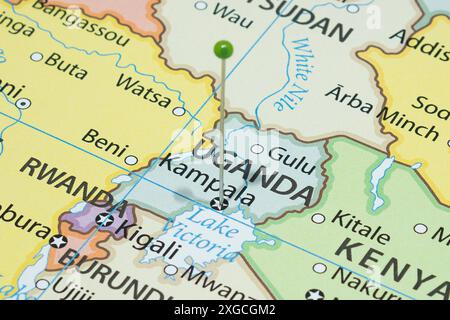 Macro photo of Kampala with a green pin needle into Uganda country political map Stock Photo