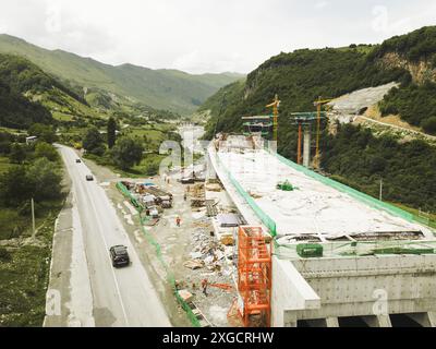 Kazbegi, Georgia - 7th july, 2024: aerial view cranes and bridge foundation pillars on construction site of new highway road project built by chinese Stock Photo