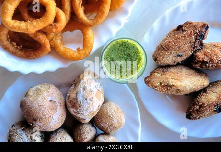 Breaded grilled squid rings with salted potatoes, fish cakes and pesto sauce. Stock Photo