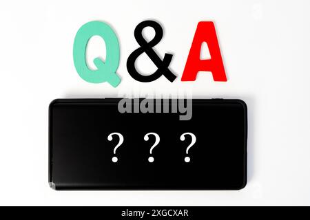 Questions and Answers Q&A session concept with hands holding modern tablet or smartphone to be used as slide background. Stock Photo