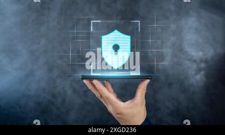 Cyber security technology and data protection privacy concepts. Shield icon on futuristic transparent smart mobile phone in hand surrounded with binar Stock Photo