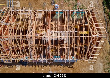 New house under construction, wooden truss system forming roof. Process of building project. Stock Photo