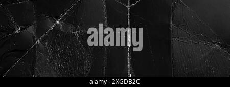 Wrinkled black paper banner with frayed chaotic wrinkles and distressed cardboard textures. Aged used wrapping sheet for quality abstract background Stock Photo