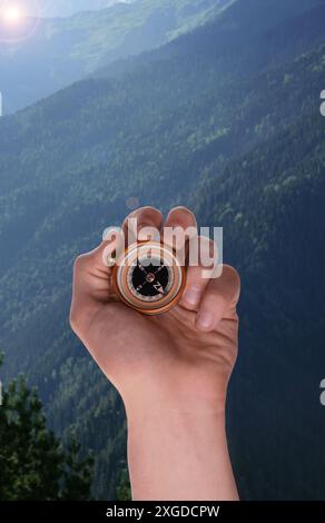 Man using compass in mountains, closeup. Navigational instrument Stock Photo