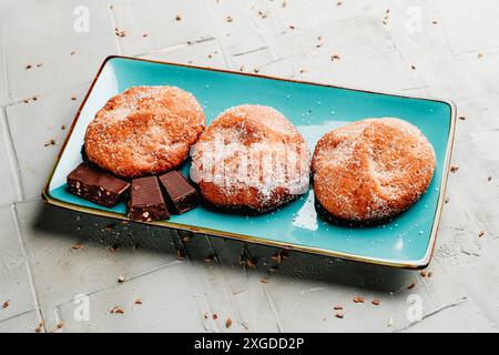 a blue ceramic plate with some panoli, a typical pastry from Terres del Ebre, in Catalonia, Spain, on a gray textured surface Stock Photo