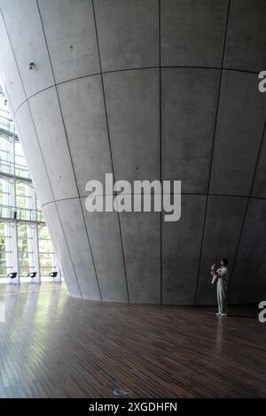 Women on with Mobile Phone taking a photo in the Foyer at The National Art Center in Tokyo Japan Stock Photo