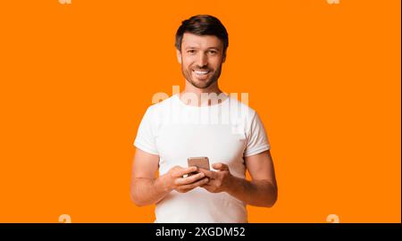 Smiling Man Using Smartphone, Studio Shot, Panorama Stock Photo