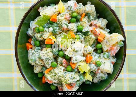 Potato salad with potatoes, carrots, peas, onions, soy yogurt, pickles and dill. Stock Photo