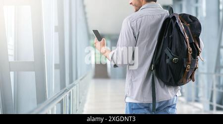 Unrecognizable Man Walking In Airport Terminal And Using Smartphone, Browsing Internet Stock Photo