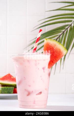 Tasty sweet watermelon milkshake or creamy slushie cocktail, garnished with watermelon slice in plastic cup, copy space Stock Photo